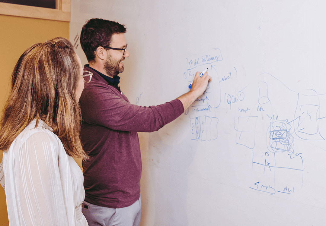 team members brainstorming two women sitting at a table discussing